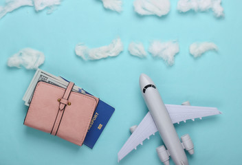 Flat lay design of travel concept with plane, clouds and tourist accessories. Minimalism. Top view