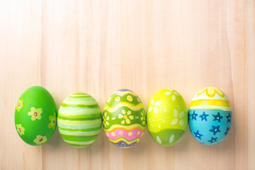 Happy Easter with colorful eggs at paintbrush for do it yourself on brown wooden floor top view with copy space