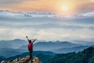Young traveler standing on top of cliff on mountains at sunrise in the morring. © ParinPIX