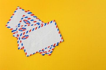 Blank white airmail envelope on yellow background.