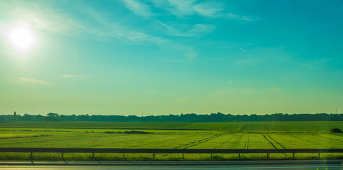 Germany, Frankfurt, Sunrise, a large long train on a lush green field