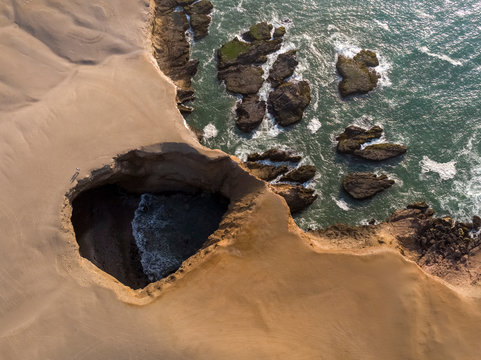 Aerial view of a rocky beach with green-blue seawater at Huarmey&acute;s seaside in Ancash region, Peru