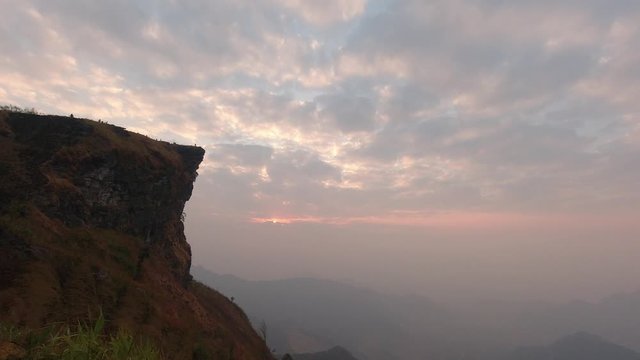 Time lapse of beautiful sunrise at Phu Chi Fah National Park, A tourist destination on a hilltop during the foggy and beautiful light in the morning and sunset in Chiang Rai Thailand 