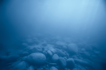 stones at the bottom underwater landscape, abstract blurred under water background