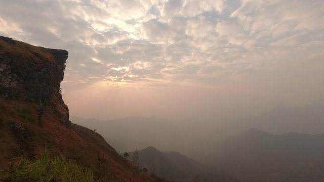 Time lapse of beautiful sunrise at Phu Chi Fah National Park, A tourist destination on a hilltop during the foggy and beautiful light in the morning and sunset in Chiang Rai Thailand 