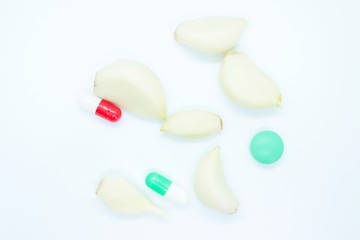 Garlic, vitamin pills, medicine located on a white background