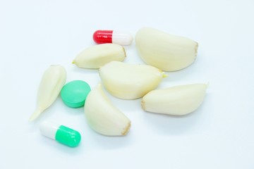 Garlic, vitamin pills, medicine located on a white background