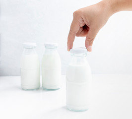 Woman hand's holding a cap of glass bottle milk isolated on white table background for food and healthy concept. with copy space for text.