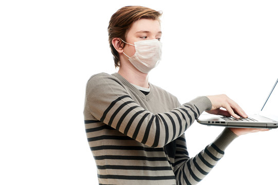 Isolate photo of Caucasian guy in medical mask with a laptop in his hands