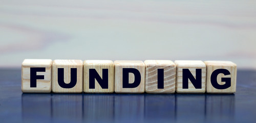 concept word funding on wooden cubes on a beautiful background