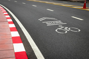 The symbol of the bike lane on the street. Sign on the cycling way meaning please share lane for bikers.
