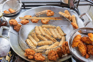 Deep fried sweet corn, tofu and taro street vendor. The frying oil is placed in the middle, heated at a high temperature after placed on the drying rack for the excess oil to drip off.