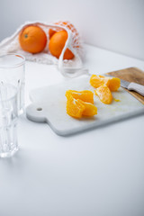 Orange cuts on a marble background. Fresh citrus fruits arranged, cut and whole with copy space