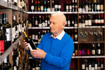 Elderly man chooses red wine