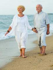 mature man and woman on the sea shore barefoot