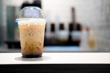 Ice milk tea on wooden table at cafe shop
