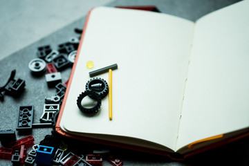 Empty paper notebooks with colorful plastic building blocks