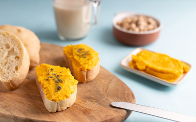 Homemade hummus chickpea spread made of chickpea, carrots, lemon and coriander. Spread over a toast, made of organic ingredients. Refreshing vegan breakfast.