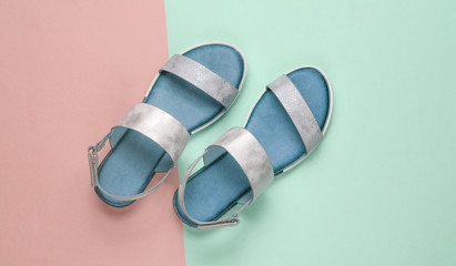 Leather female sandals on a pastel blue-pink background. Summer footwear, Top view