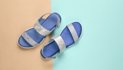 Leather female sandals on a pastel blue-pink background. Summer footwear, Top view