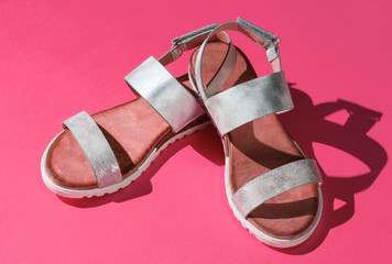 Stylish women's sandals on pink background. Summer footwear
