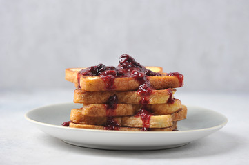 Toast with berry jam on a plate. Light background. Close-up. Free space for text.
