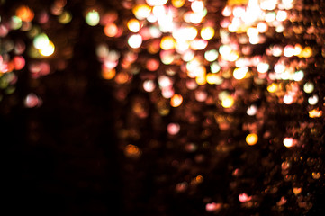 Bokeh blurred abstract lights colored on black glitter shiny sparkle background