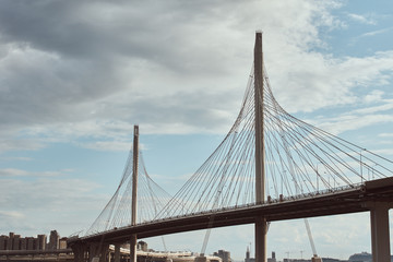 modern cable stayed bridge over the river against cloudy sky. Engineering construction closeup