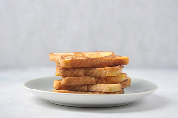 White bread toasts on a plate. Light background. Close-up. Free space for text.