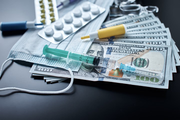 Pills, protective mask, medical items and dollar bills on dark background. Expensive medicine concept. Pharmaceutical industry and medical insurance