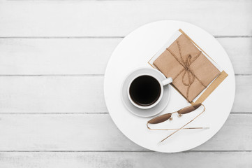 Coffee cup, glasses and letters correspondence on a white table wooden background.  Top view. Flat lay