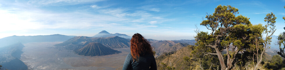 Fototapeta na wymiar Beautiful woman with red hair watching over Mt Bromo volcano in Java Indonesia