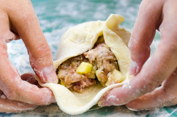 Close up of young woman hands making sandwich from flour and meat in the home kitchen. - 328827764