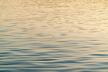 Sea surface with waves in sunset colors