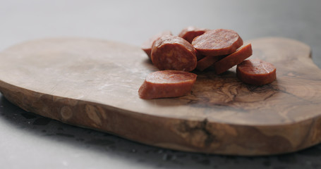 chorizo slices on olive wood board closeup