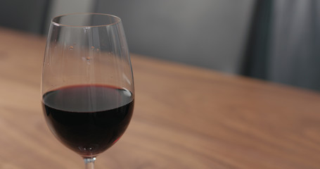 wineglass with red wine on walnut table with copy space