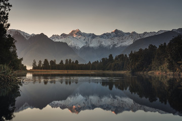 Sunrise at lake Matheson with reflection of mount Cook and mount Tasman, Fox glacier, South island, New Zealand.