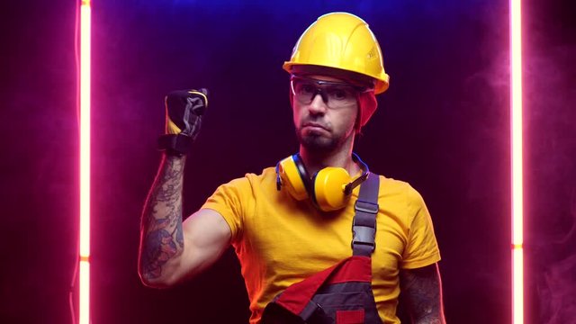 a construction worker in a hard hat puts on gloves