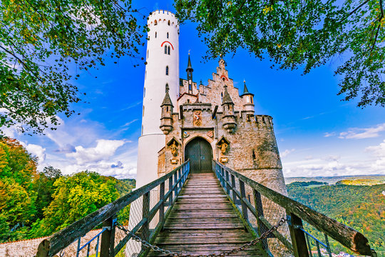 Germany, Lichtenstein Castle in Baden-Wurttemberg land in Swabian Alps. Seasonal view of Lichtenstein Castle on a cliff circled by trees with yellow foliage. European famous landmark.