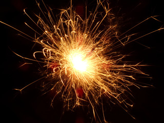 Sparkler close -up. Sparkler on a holiday. Lots of bright sparks on a black background. Pyrotechnics and fireworks for the holiday.
