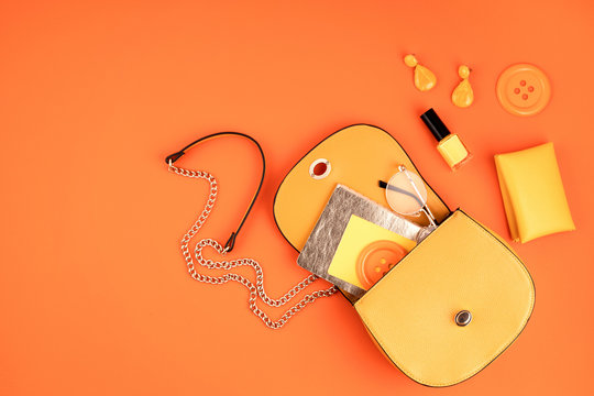 Flat lay with woman fashion accessories in yellow color over orange yellow textured background. Fashion, online beauty blog, summer style, shopping and trends idea