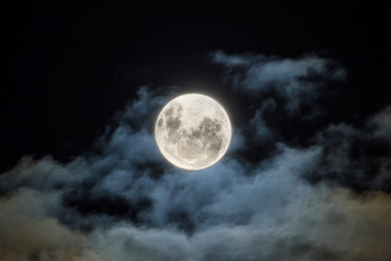 Naklejka na ściany i meble The full moon, with wispy white clouds around it