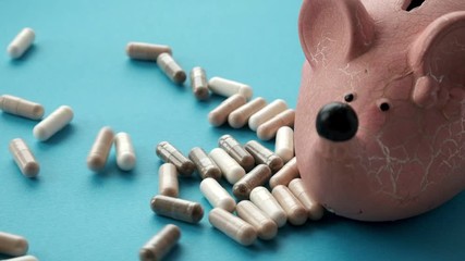 concept of expensive drugs. pills and tablets fall moneybox. slow motion video - Powered by Adobe