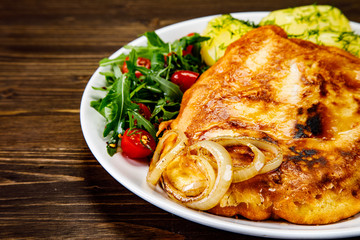 Schnitzel with boiled potatoes on timber background