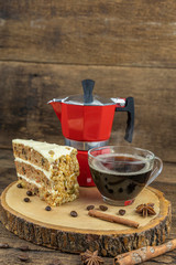 A cup of hot coffee with cake and italian coffee pot(Moka) on wooden table.