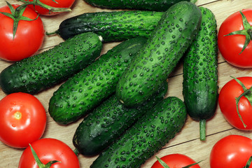 Tomatoes and cucumbers on a wooden table. Healthy, vegetarian food. Natural food.Vegetables on a table. Flat lay.