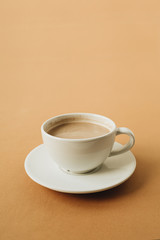 Cup of coffee with milk on ginger background. Minimal breakfast concept.