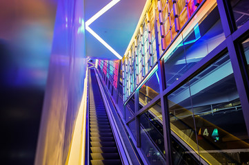 escalator with LED light beside in technology abstract neon colorful light theme.