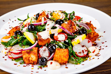Fried chicken breast and vegetables on wooden table