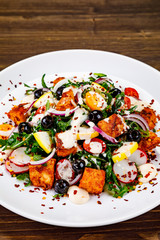 Fried chicken breast and vegetables on wooden table